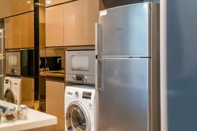 a kitchen with a stainless steel refrigerator and a washing machine at Dorsett Bukit Bintang 5min to Pavilion KL in Kuala Lumpur