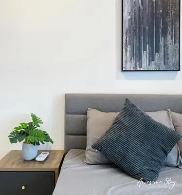 a bed with a pillow and a potted plant on it at Trion KL By Holidayhome in Kuala Lumpur