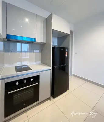 a kitchen with a black refrigerator and white cabinets at Trion KL By Holidayhome in Kuala Lumpur