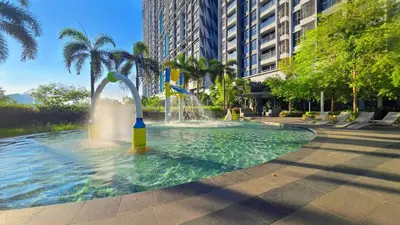 a fountain in the middle of a pool of water at Trion KL Service Suite - Modern City Stay with Pool & Gym in Kuala Lumpur