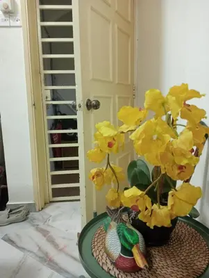 a vase filled with yellow flowers on a table at have fun staying here in Kuala Lumpur