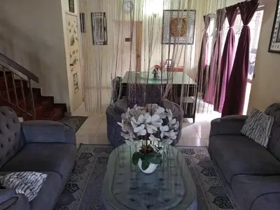 a living room with couches and a table with flowers on it at have fun staying here in Kuala Lumpur