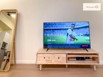 a flat screen tv sitting on top of a wooden entertainment center at KLCC View & Netflix & Walk to LRT & Sunway Putra in Kuala Lumpur
