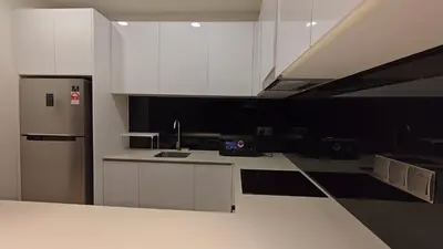 a kitchen with white cabinets and a stainless steel refrigerator at Star Residence KLCC By LLKOK in Kuala Lumpur