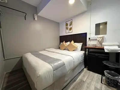 a bedroom with a bed and a desk with a phone at SS Grey House Bukit Bintang in Kuala Lumpur