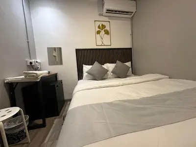 a bedroom with a large white bed and a telephone at SS Grey House Bukit Bintang in Kuala Lumpur