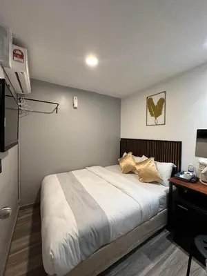 a bedroom with a bed and a desk and a television at SS Grey House Bukit Bintang in Kuala Lumpur