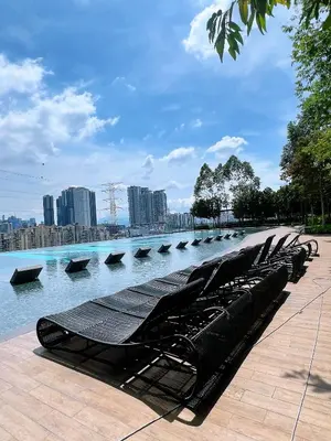 a row of benches sitting next to a body of water at M VERTICA Isyak Homestay in Kuala Lumpur