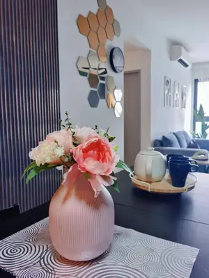 a pink vase with flowers sitting on a table at M VERTICA Isyak Homestay in Kuala Lumpur
