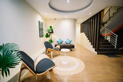 a living room with a couch and a table and chairs at Swing & Pillows - Sungei Wang Bukit Bintang in Kuala Lumpur