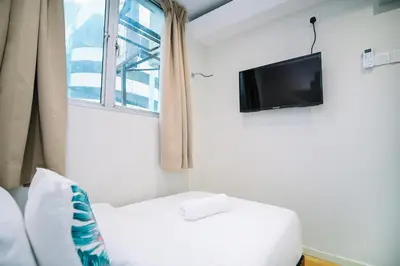 a room with a bed and a tv and a window at Swing & Pillows - Sungei Wang Bukit Bintang in Kuala Lumpur