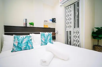a bedroom with a white bed with blue and white pillows at Swing & Pillows - Sungei Wang Bukit Bintang in Kuala Lumpur