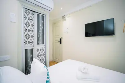 a bedroom with a bed and a tv on the wall at Swing & Pillows - Sungei Wang Bukit Bintang in Kuala Lumpur