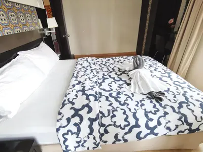 a bed with a blue and white blanket on it at Seri Bukit Ceylon Bukit Bintang in Kuala Lumpur