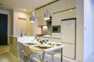 a kitchen with a table with chairs and a refrigerator at Sama Suites at Platinum KLCC Bukit Bintang in Kuala Lumpur