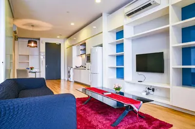 a living room with a blue couch and a tv at Sama Suites at Platinum KLCC Bukit Bintang in Kuala Lumpur