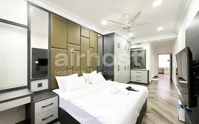 a bedroom with a large white bed and a tv at Family House at Setiawangsa by Airhost in Kuala Lumpur