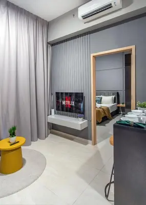 a living room with a fireplace and a bedroom at The Colony & Luxe Kuala Lumpur with KLCC View Skypool by COBNB in Kuala Lumpur
