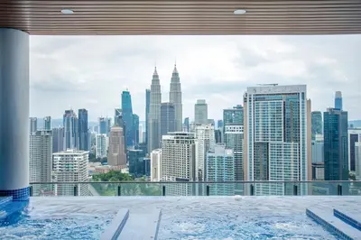 a view of a city skyline from a hot tub at The Colony & Luxe Kuala Lumpur with KLCC View Skypool by COBNB in Kuala Lumpur