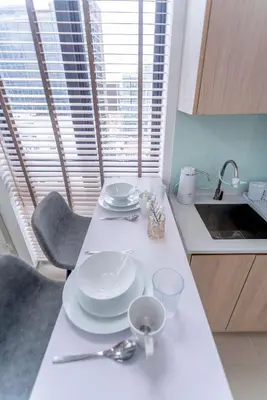 a kitchen with a table with plates and spoons on it at The Colony & Luxe Kuala Lumpur with KLCC View Skypool by COBNB in Kuala Lumpur