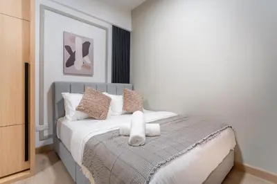 a bedroom with a bed with white sheets and pillows at The Colony & Luxe Kuala Lumpur with KLCC View Skypool by COBNB in Kuala Lumpur