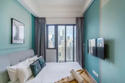 a bedroom with a bed and a large window at The Colony & Luxe Kuala Lumpur with KLCC View Skypool by COBNB in Kuala Lumpur