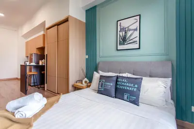 a bedroom with a bed with a blue wall at The Colony & Luxe Kuala Lumpur with KLCC View Skypool by COBNB in Kuala Lumpur