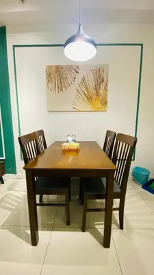 a wooden dining room table with two chairs and a light at Chamber suites KLCC by Global stay in Kuala Lumpur