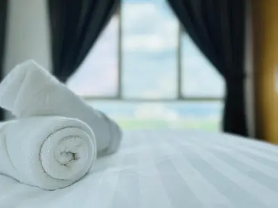 a white towel sitting on top of a bed at 231TR Service Suites by DeUrban in Kuala Lumpur