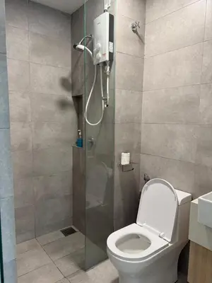a bathroom with a shower with a toilet and a glass door at KL Sentral city retreats with KLCC views in Kuala Lumpur