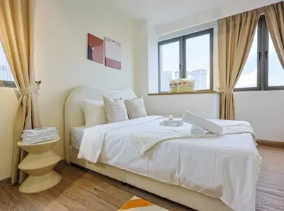 a white bedroom with a bed and a window at KL Sentral city retreats with KLCC views in Kuala Lumpur