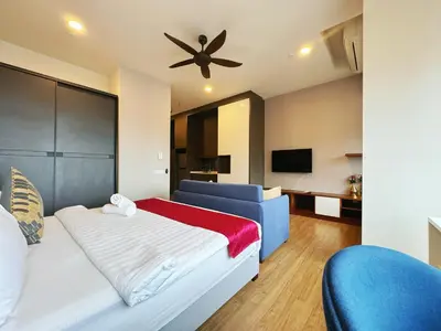 a bedroom with a bed and a couch and a ceiling fan at Ceylonz Suites KLCC by WSD in Kuala Lumpur