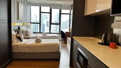 a hotel room with two beds and a kitchen with windows at Ceylonz Suites KLCC by WSD in Kuala Lumpur