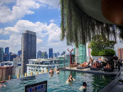 a pool on the roof of a building with people swimming at Ceylonz Suites KLCC by WSD in Kuala Lumpur