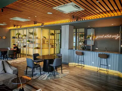 a lobby with a table and chairs and a person at Ceylonz Suites KLCC by WSD in Kuala Lumpur