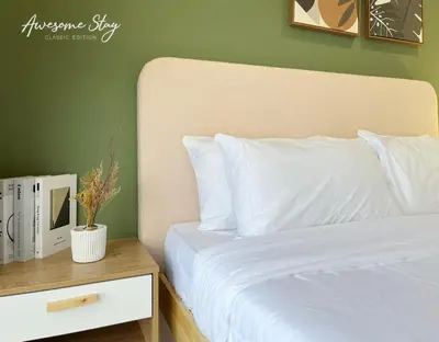 a bedroom with a white bed and a night stand with a nightstand at Trion KL By The Relaxstay in Kuala Lumpur