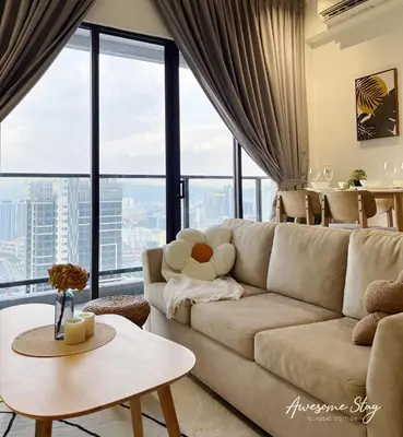a living room with a couch and large windows at Trion KL By The Relaxstay in Kuala Lumpur