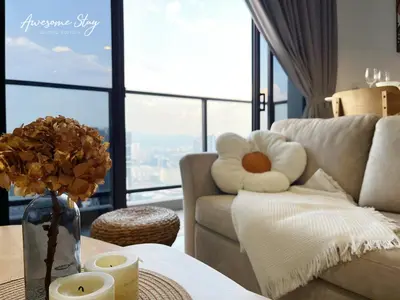 a living room with a couch and a table with flowers at Trion KL By The Relaxstay in Kuala Lumpur