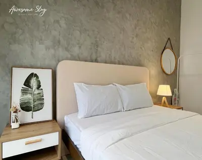 a bedroom with a bed and a picture of a plant at Trion KL By The Relaxstay in Kuala Lumpur