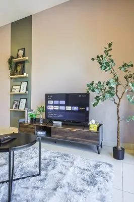 a living room with a tv on a wooden entertainment center at Trion Kuala Lumpur by Vivid Stay in Kuala Lumpur