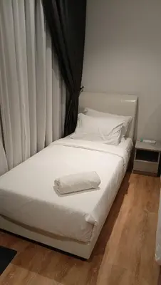a white bed with a towel on top of it at Quill Residence- Minimalist Urban Condo by Azmila in Kuala Lumpur