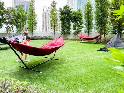 a person standing in a hammock in a yard at 2BR2B Hozem KL4906 Apartment Bukit Bintang in Kuala Lumpur