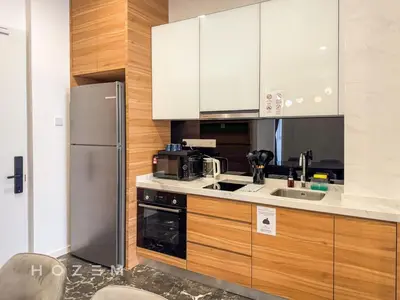 a kitchen with white cabinets and a stainless steel refrigerator at 2BR2B Hozem KL4910 Apartment KLCC in Kuala Lumpur