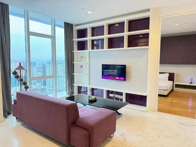 a living room with a couch and a tv at The Platinum Suites KLCC in Kuala Lumpur