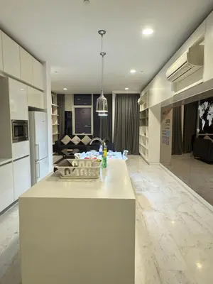 a kitchen with a white island in a living room at The Platinum Suites KLCC in Kuala Lumpur