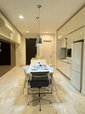 a kitchen with a table with chairs and a refrigerator at The Platinum Suites KLCC in Kuala Lumpur