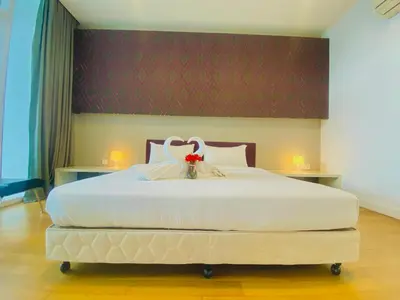 a bedroom with a large white bed with a flower on it at The Platinum Suites KLCC in Kuala Lumpur