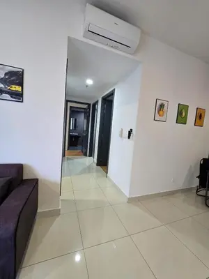 a living room with a couch and a white wall at Inspirasi Mont Kiara Cozy Homestay with Pool View Kuala Lumpur in Kuala Lumpur