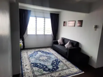 a living room with a couch and a rug and a window at Homestay Lala in Kuala Lumpur