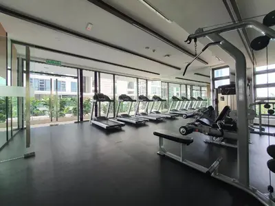 a gym with a row of treadmills and machines at The Signature Suites at Robertson Bukit Bintang in Kuala Lumpur